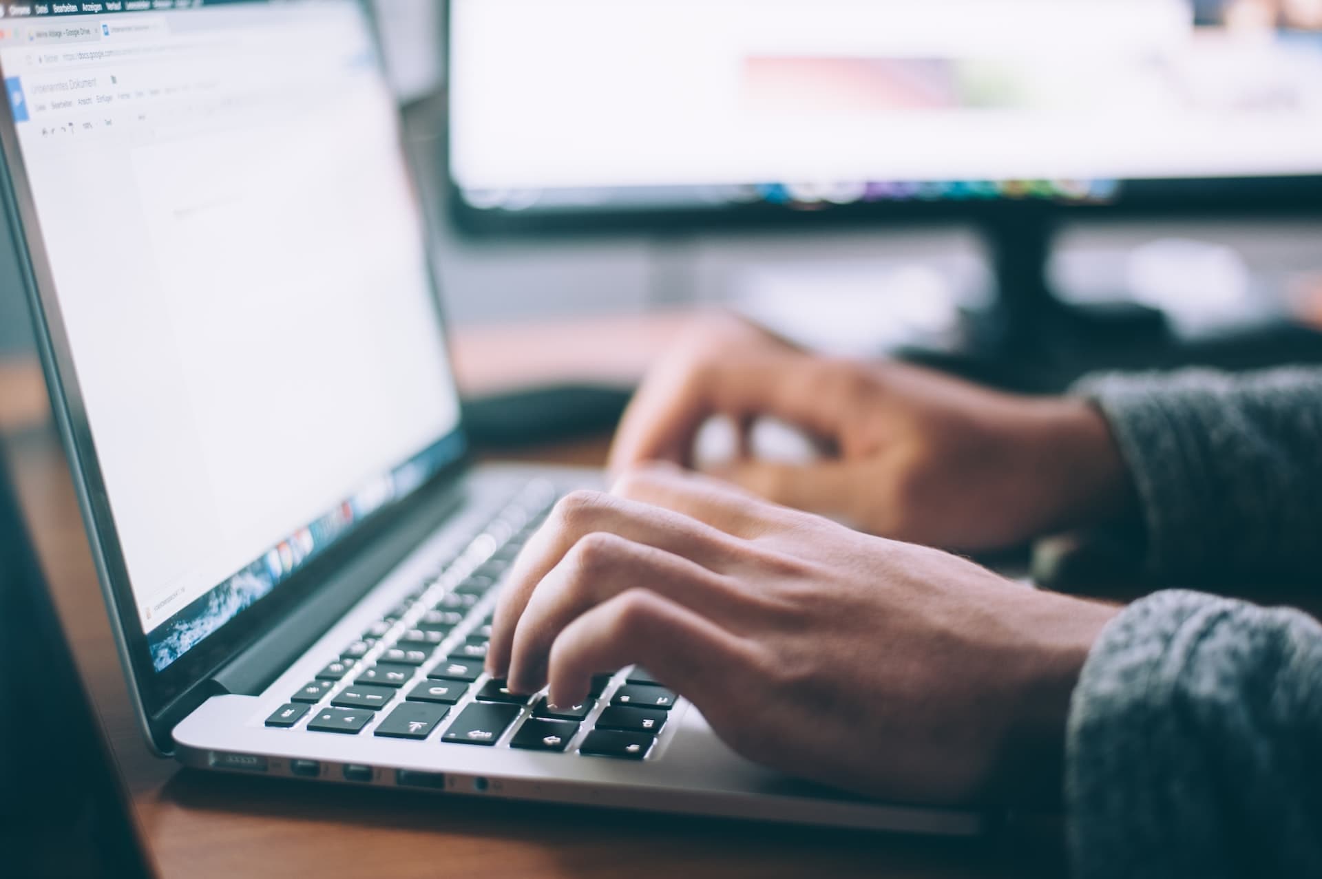 Fingers typing on a macbook