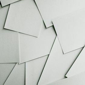Übereinander liegende weiße Papierblätter in einem ungeordneten Muster.